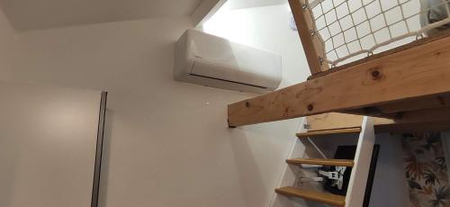 a kitchen with a shelf and a light on a wall at Studio Cosy proche Futuroscope in Montamisé