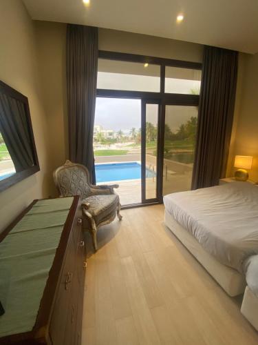 a bedroom with a bed and a view of a pool at Villa Rotana Tulip in Salalah