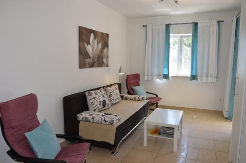 a living room with a couch and chairs at Apartments Sandra in Brseč
