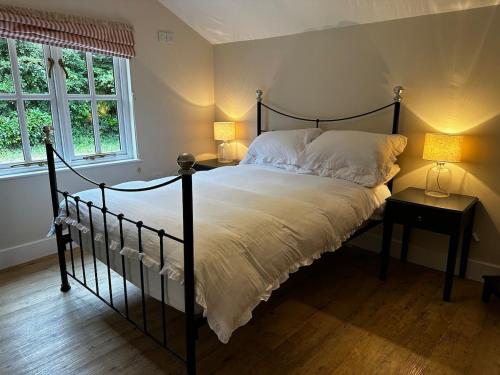 a bedroom with a bed with two lamps and two tables at Nature lovers retreat - New Forest in Ibsley