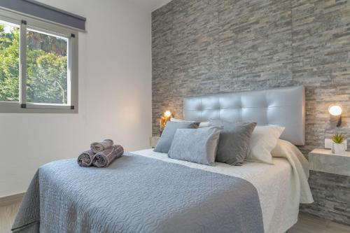 Un dormitorio con una cama grande con una pared de ladrillo. en Villa el Olivar 1, en Barbate