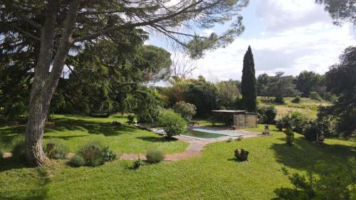 un jardin avec une piscine et des arbres dans l'établissement Domaine Les Olivoux, à Pomport