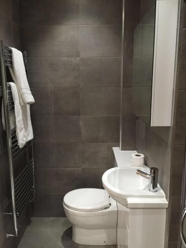 a bathroom with a white toilet and a sink at Lincoln Retreat in Lincoln