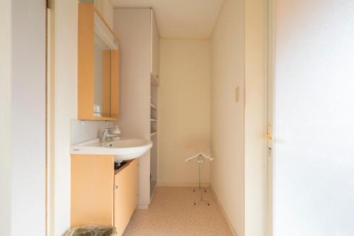 a small bathroom with a sink and a mirror at Le Nessa Jyogasaki in Ito