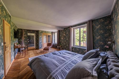 a bedroom with a bed in a room with wallpaper at Chateau le grand bus in Saint Germain la Campagne