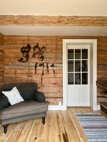 a living room with a couch and a wooden wall at Snickarboden in Ingelstad