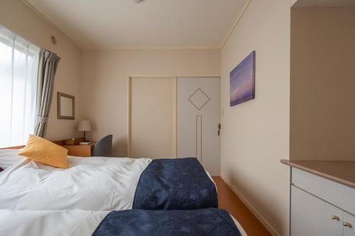 a small bedroom with a bed and a window at Le Nessa Jyogasaki in Ito