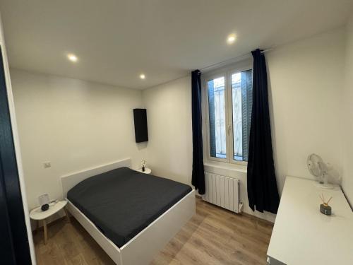 un dormitorio con una cama y una ventana en Villa LARRIEU, en Toulouse