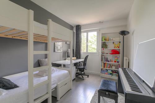 une chambre avec deux lits superposés et un bureau dans l'établissement T3 lumineux pour 6 personnes proche métro Lyon, à Caluire-et-Cuire