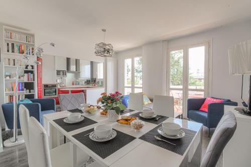 une cuisine et une salle à manger avec une table et des chaises dans l'établissement T3 lumineux pour 6 personnes proche métro Lyon, à Caluire-et-Cuire