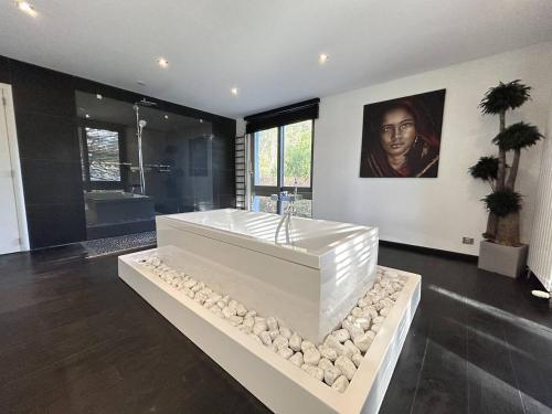 un salon avec une grande baignoire blanche avec des pierres dans l'établissement LaMaisonBlanche, à Le Touquet-Paris-Plage