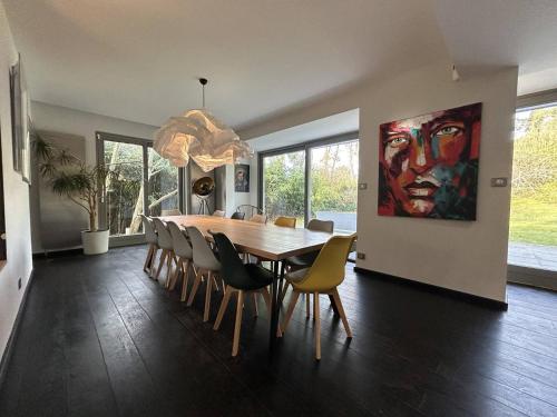 une salle à manger avec une table et des chaises et un tableau dans l'établissement LaMaisonBlanche, à Le Touquet-Paris-Plage