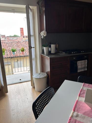 a kitchen with a table and a view of a balcony at Bon Bon Luxury di piazza San Secondo in Asti