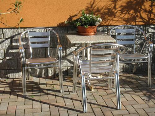 three chairs and a table with a potted plant on a patio at La Collina in Casnate con Bernate