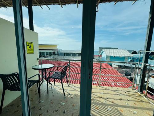 a patio with a table and chairs on a balcony at Baan Ta Long Beach Koh Larn in Ko Larn