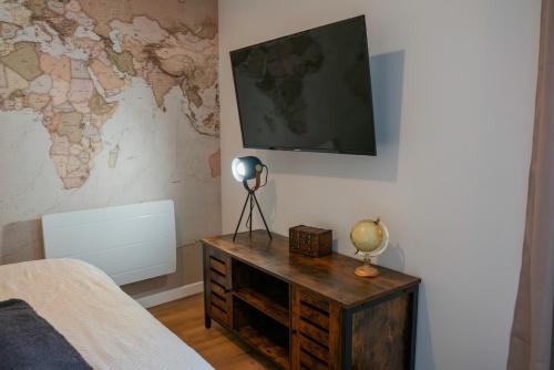 - une chambre avec un bureau et une télévision murale dans l'établissement Globetrotteur Votre Escale Confort à Saint Brieuc, à Saint-Brieuc