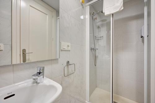 a white bathroom with a sink and a shower at El Mirador de la Estafeta by Clabao in Pamplona