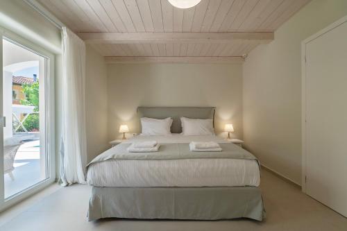 a bedroom with a bed and a large window at Parga Villas in Parga
