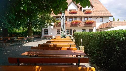 a row of wooden benches in front of a building at Landgasthof Hummel in Ebensfeld