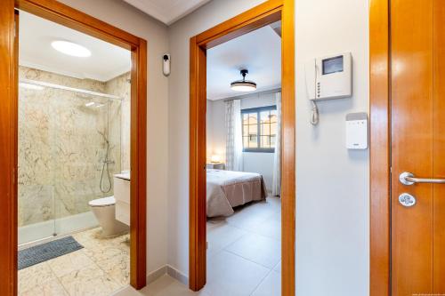 a bathroom with a shower and a toilet and a bed at Del Duque Ocean View Terrace in Adeje