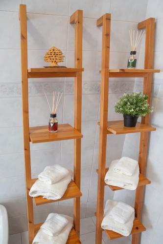 a wooden shelf with towels and a potted plant at Tra il Vesuvio e il Mare Apartment in Torre del Greco