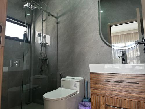 a bathroom with a toilet and a shower and a sink at Eakmongkol Luxury Five-Bedroom Pool Villa in Jomtien Beach