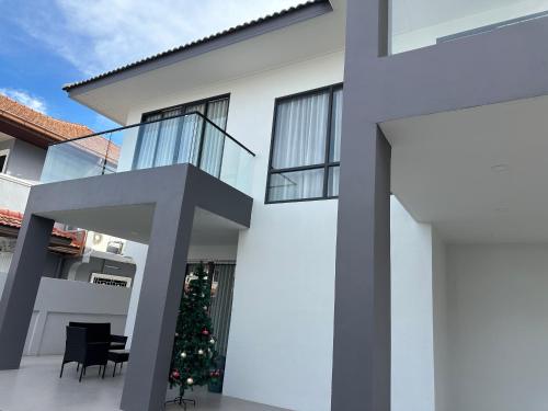 a white house with a christmas tree in the courtyard at Eakmongkol Luxury Five-Bedroom Pool Villa in Jomtien Beach