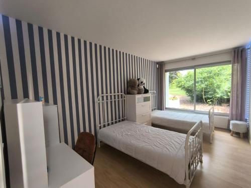 une chambre avec un lit avec un ours en peluche dessus dans l'établissement Maison d'architecte avec foret et immense jardin, à Saintes