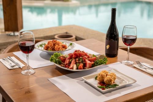 a table with two plates of food and a bottle of wine at Aegean Houses in Kos Town