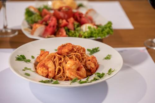 two plates of food on a table with pasta at Aegean Houses in Kos Town