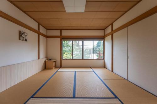 an empty room with a window and mats on the floor at Le Nessa Jyogasaki in Ito
