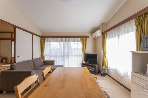a living room with a couch and a table at Le Nessa Jyogasaki in Ito