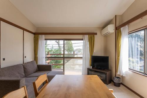 a living room with a table and a couch at Le Nessa Jyogasaki in Ito