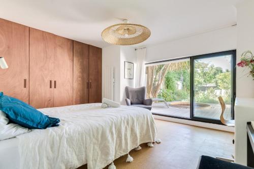 une chambre avec un grand lit et une grande fenêtre dans l'établissement Seaside architect contemporary house, à Marseille