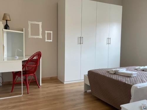 a bedroom with a bed and a desk with a red chair at Il Nido Sui Tetti in Stradella