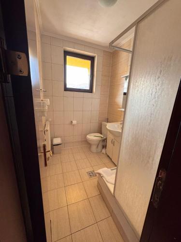 a bathroom with a toilet and a window at Casa Maria Azuga by Genco in Azuga
