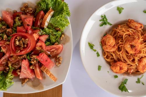 a plate of pasta and a bowl of salad at Aegean Houses in Kos Town