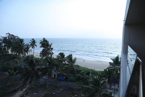 a view of a beach with palm trees and the ocean at Palm Breeze Beach Resort in Mangalore