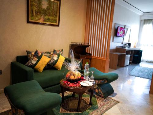 a living room with a green couch and a table at Menzeh Zalagh 2Boutique Hôtel & Sky in Fès