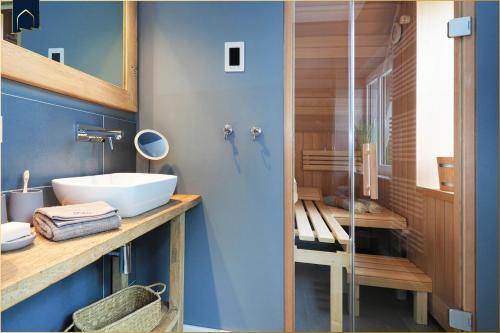 a bathroom with a sink and a glass shower at Störtebekers Reethus mit Sauna, Kamin und E-Ladesäule in Loddin