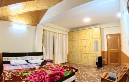a bedroom with a large bed in a room at Heavens Orchard in Manāli