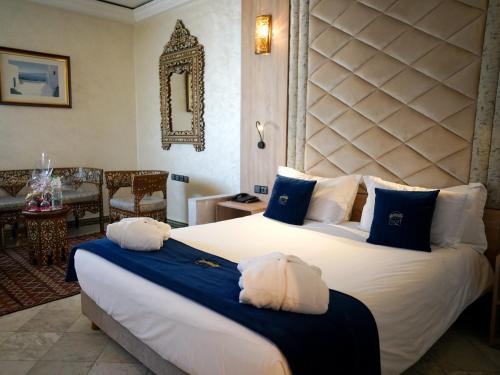 a bedroom with two beds with blue and white pillows at Menzeh Zalagh 2Boutique Hôtel & Sky in Fès