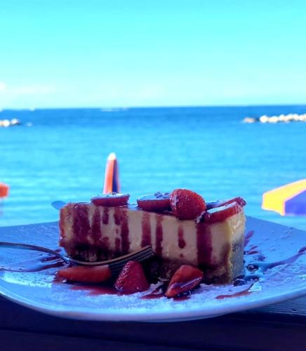a piece of cake with strawberries on a blue plate at Giamè House Ischia in Ischia