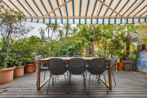 Una mesa y sillas en un patio con plantas. en LovelyLoft San Anton, en Alicante