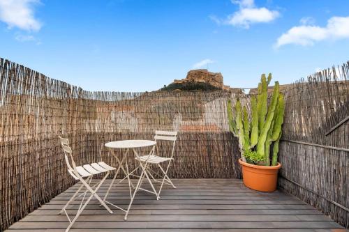 a patio with two chairs and a table and a plant at LovelyLoft San Anton in Alicante