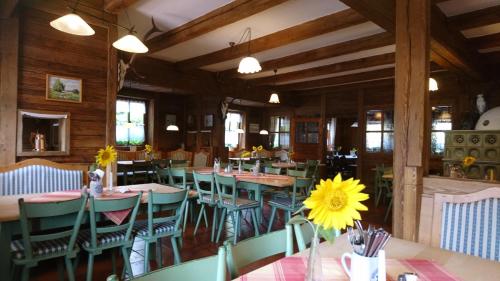 a restaurant with tables and chairs and a yellow flower in a vase at Landgasthof Hummel in Ebensfeld