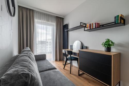 a living room with a couch and a desk at RentPlanet - Kępa Mieszczańska in Wrocław