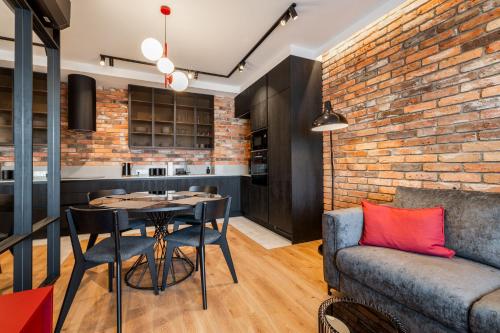 a living room with a brick wall and a table and a couch at RentPlanet - Kępa Mieszczańska in Wrocław