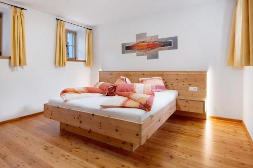 a bedroom with a wooden bed with pillows on it at Bertollhof Apfelerlebnis in Silandro