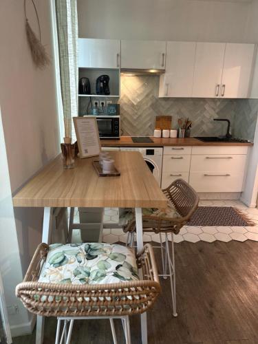 une cuisine avec une table en bois et deux chaises dans l'établissement Grand T1 de 38 m2 au design épurée, à Marseille